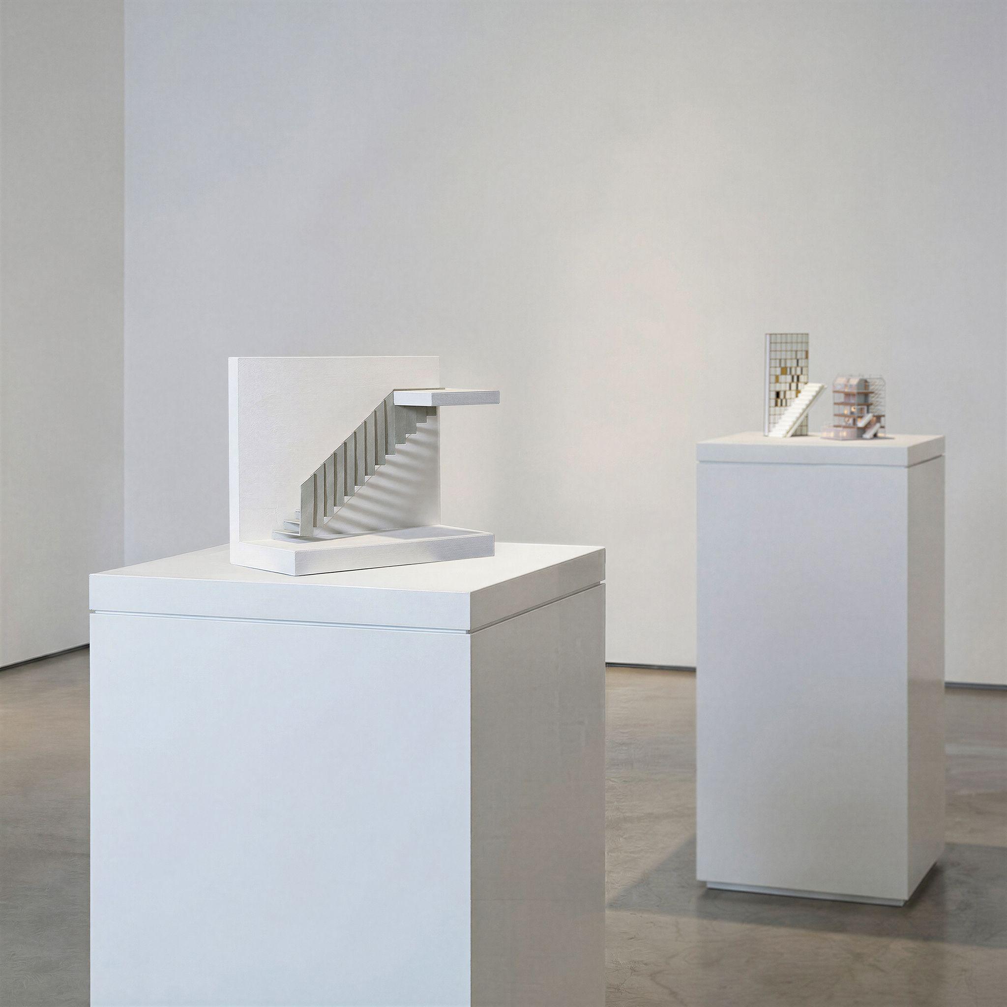 Two study models for Half Landings House on plinths, a white sectional stair model in the foreground and other models behind.