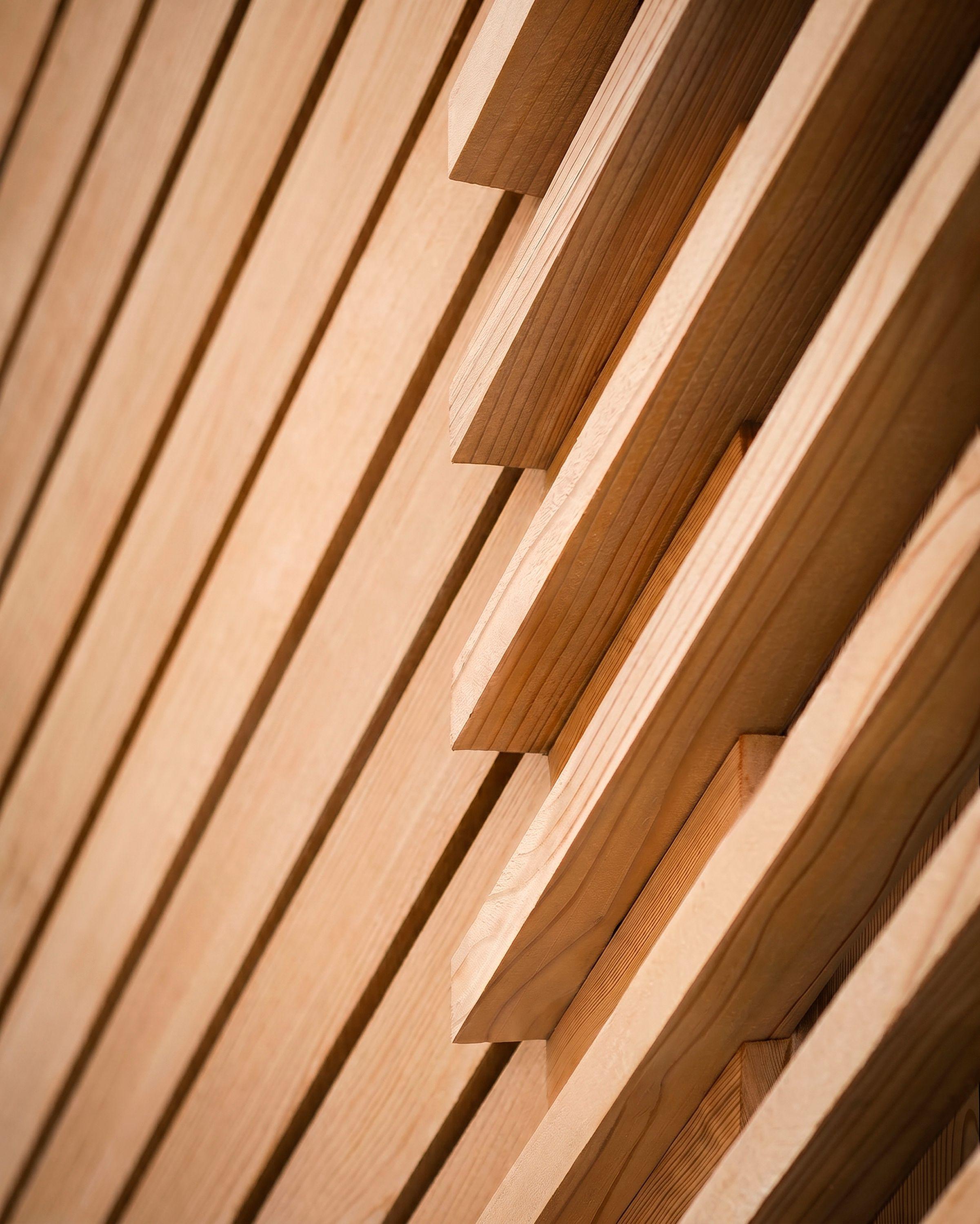 Close detail of the diagonal timber cladding at Cross Cut House, the battens stepping forward where the boarding meets an opening.
