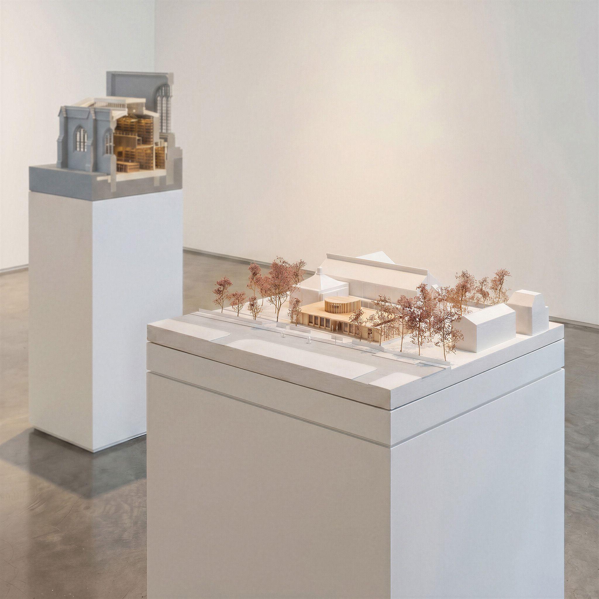 Architectural models of the entrance building at Homerton College, Cambridge and Exeter College Library, Oxford, displayed on plinths